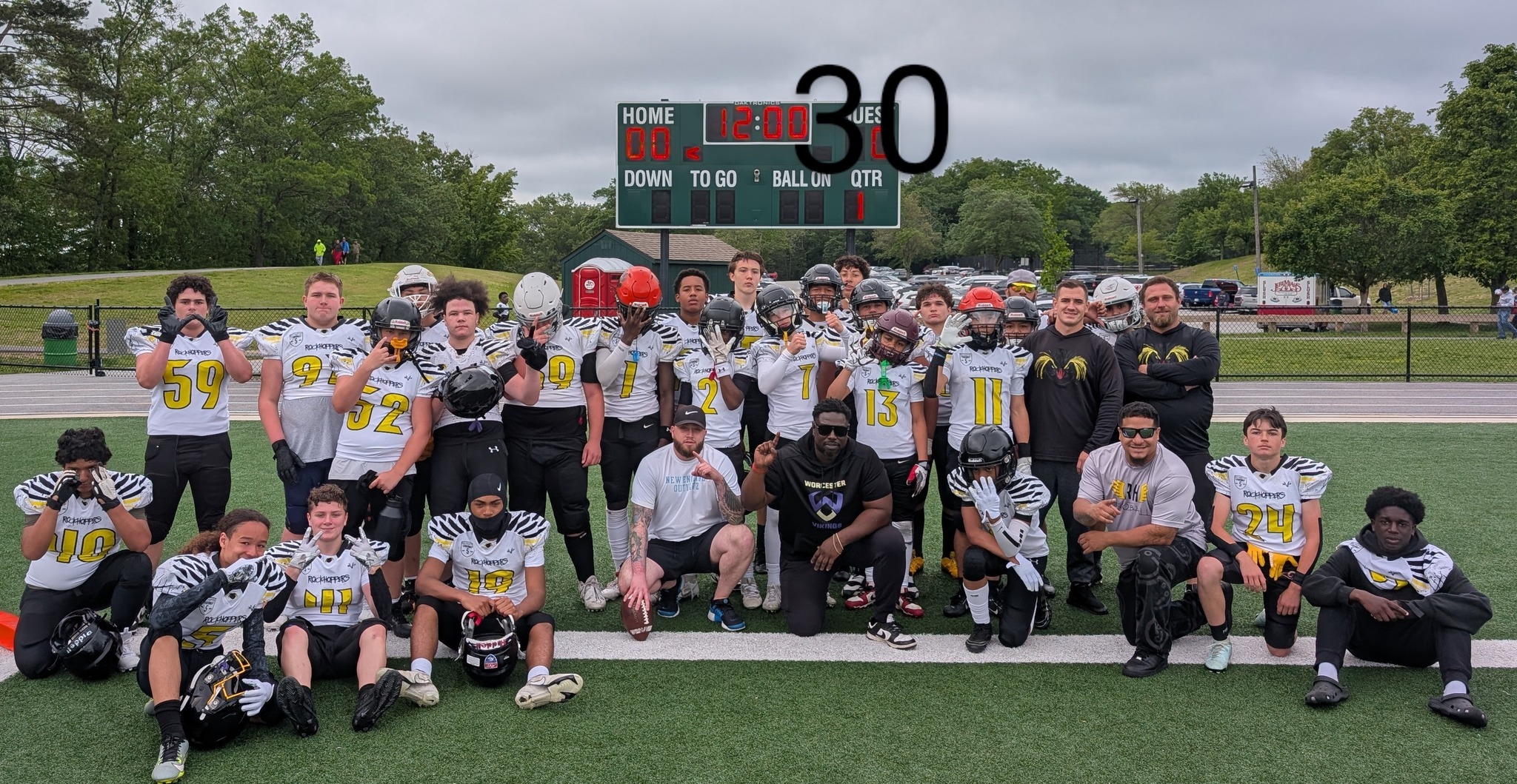 Varsity high school athletes huddling up on a football field in Massachusetts representing Rockhopper Football Club